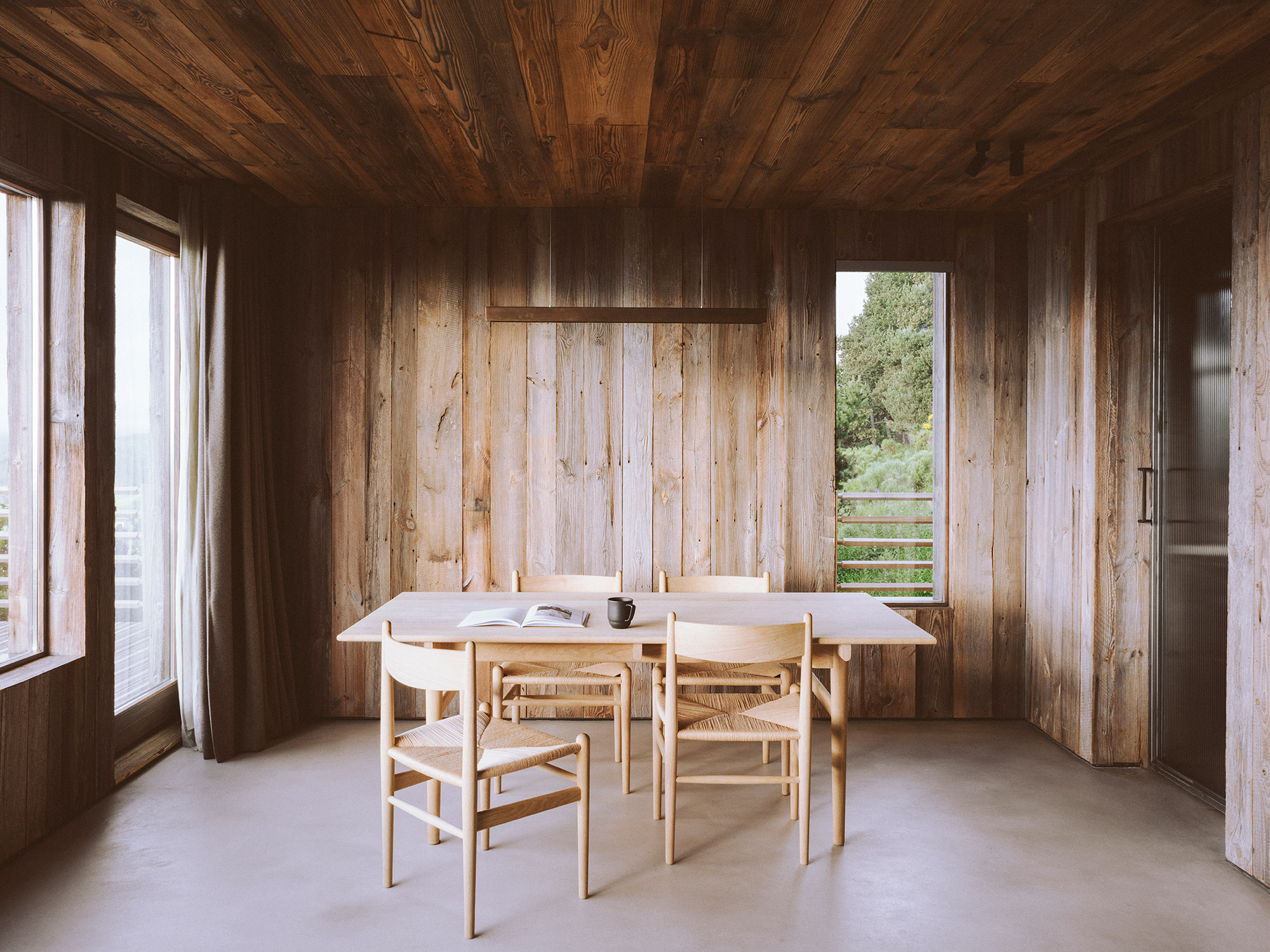 Rustic alpine chalet, darkened wood interior, concrete floor