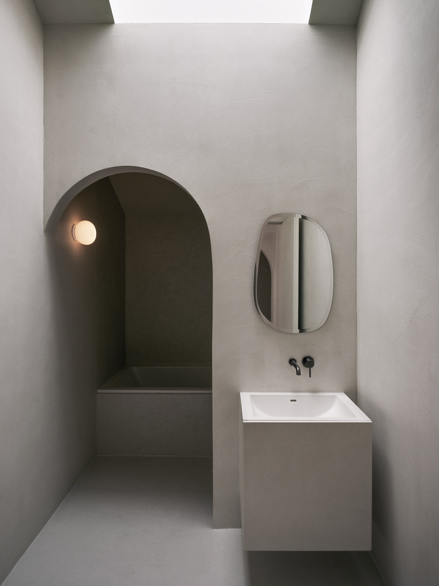 Minimalist white bathroom with oval mirror