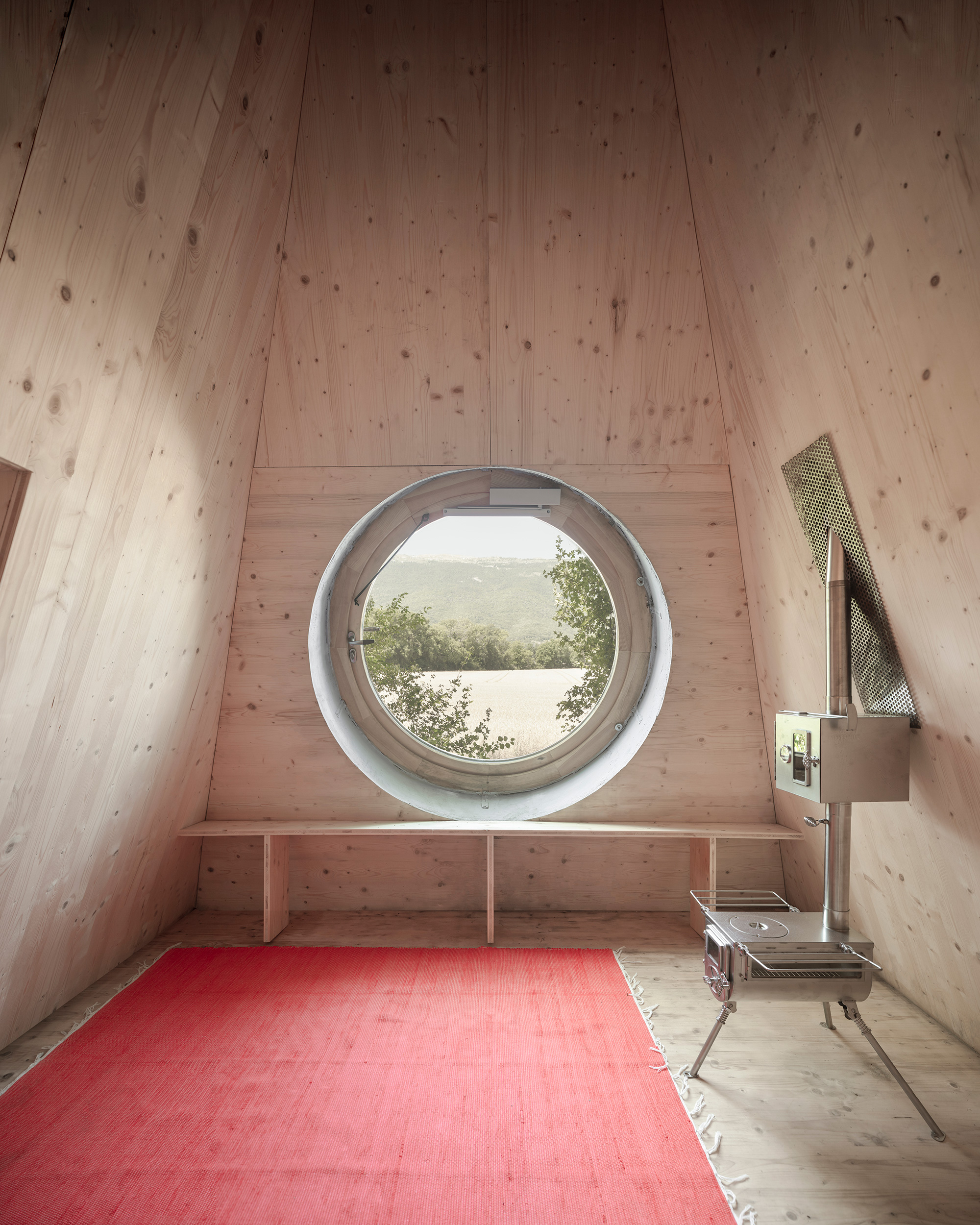 A tiny shelter designed to blend into nature with a boulder-like exterior.